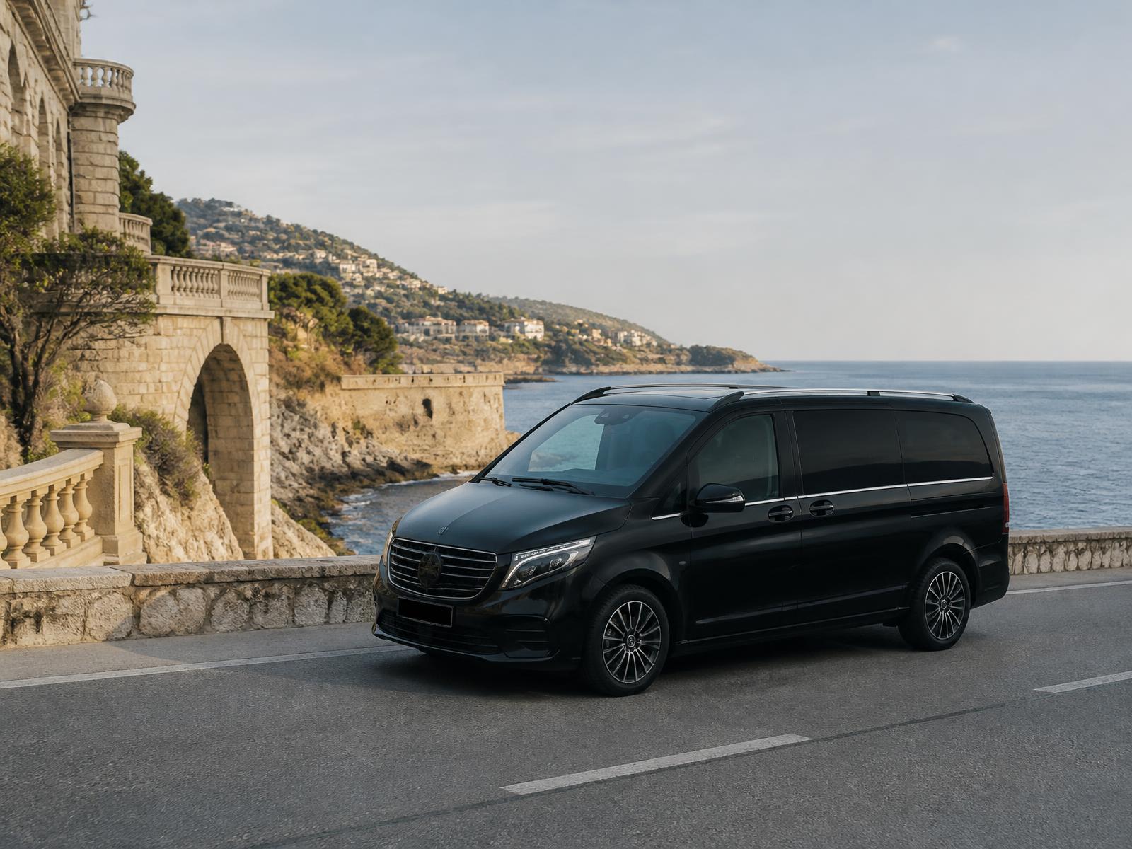Van premium noir sur une route côtière de la Côte d’Azur